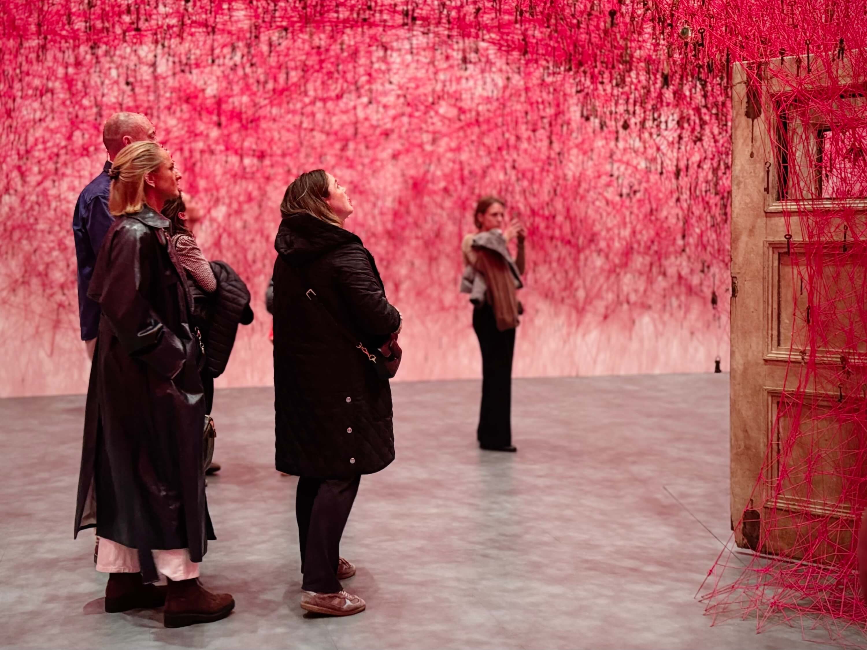 People looking at the red thread installation